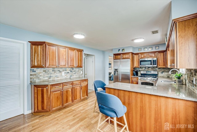 21 Stonewall Dr, Edison, NJ 08820 - kitchen featuring appliances with stainless steel finishes, brown cabinetry, tasteful backsplash, and a sink