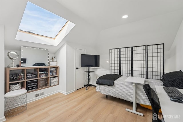 bedroom featuring vaulted ceiling with skylight, visible vents, recessed lighting, and wood finished floors