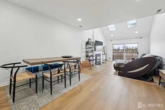 dining space featuring recessed lighting, visible vents, vaulted ceiling with skylight, and light wood-style floors