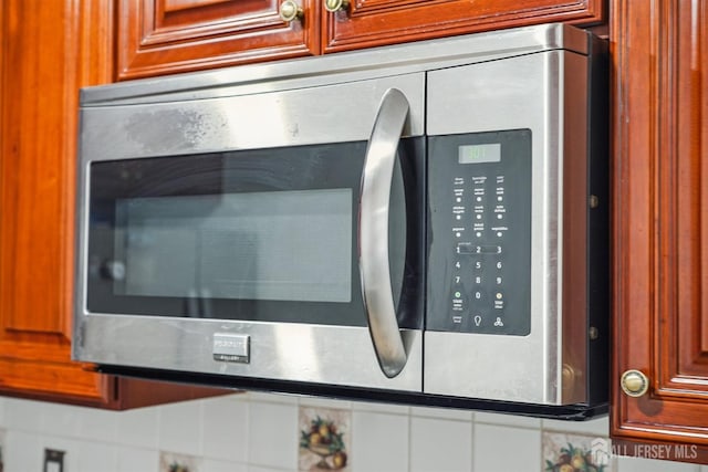 details featuring brown cabinets and stainless steel microwave