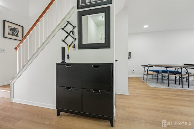 interior space featuring light wood finished floors, stairway, recessed lighting, and baseboards