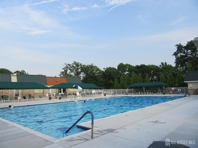 community pool featuring fence and a patio area