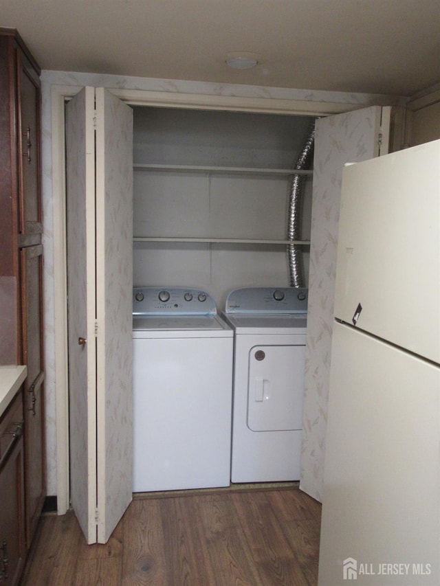 washroom with washer and dryer and wood finished floors