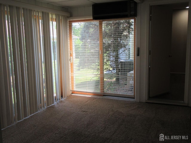 carpeted spare room featuring a wall mounted AC