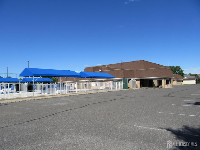 view of property with fence and uncovered parking
