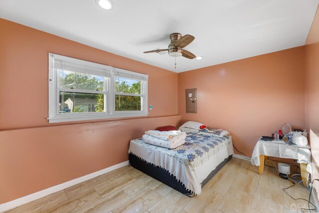 bedroom with electric panel, ceiling fan, and light hardwood / wood-style floors