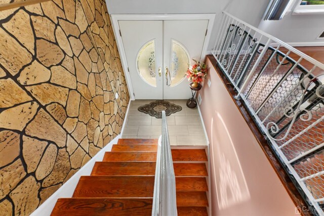 staircase with french doors and tile patterned flooring