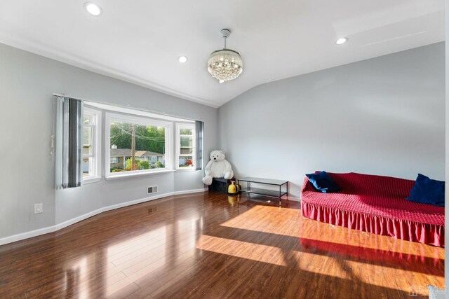 bedroom featuring lofted ceiling, wood-type flooring, and a chandelier