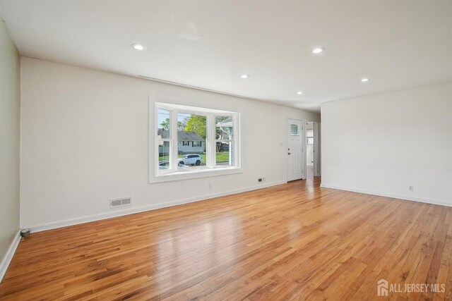 unfurnished room with recessed lighting, baseboards, light wood-type flooring, and visible vents