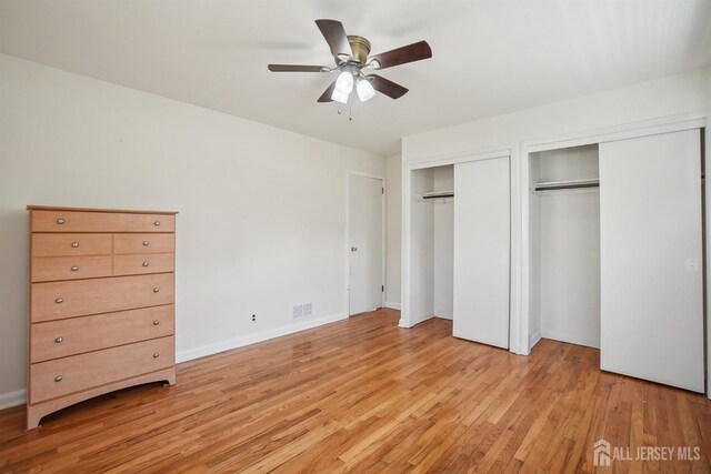 unfurnished bedroom with ceiling fan, visible vents, baseboards, multiple closets, and light wood-style flooring