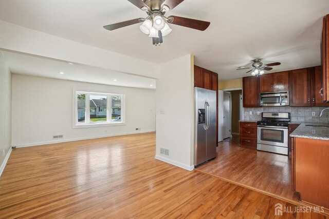 kitchen with a ceiling fan, visible vents, appliances with stainless steel finishes, a sink, and light wood-style floors