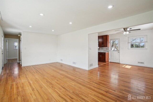 unfurnished living room featuring recessed lighting, baseboards, ceiling fan, and light wood-type flooring