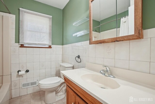 bathroom with visible vents, curtained shower, toilet, and tile walls