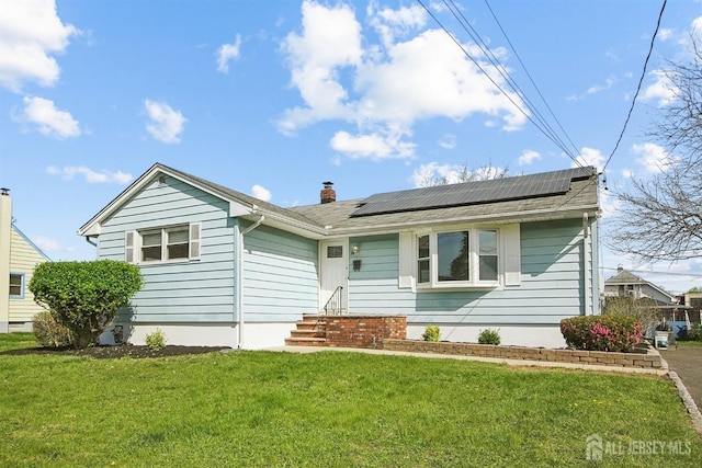 114 Woodrow Ave, Piscataway, NJ 08854 - view of front of property with a front lawn, roof mounted solar panels, and a chimney