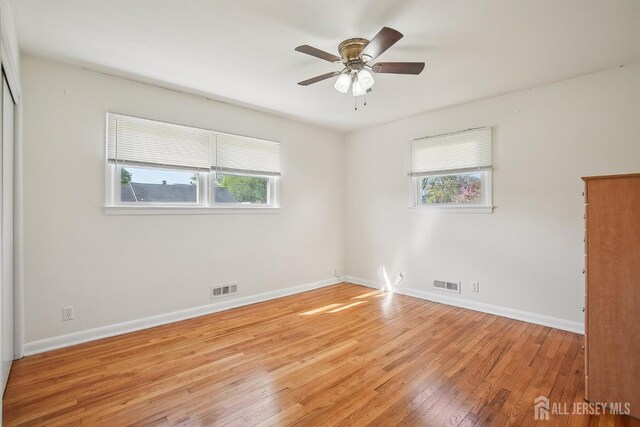 spare room featuring visible vents, light wood-style flooring, and plenty of natural light