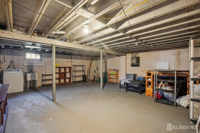 below grade area featuring a sink, washer / clothes dryer, and electric panel