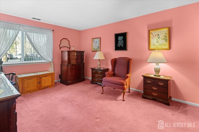 living area featuring visible vents, baseboards, and light carpet