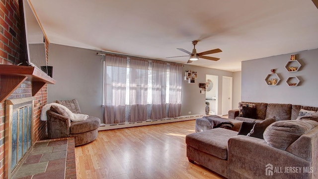 living room featuring hardwood / wood-style floors, ceiling fan, a fireplace, and baseboard heating