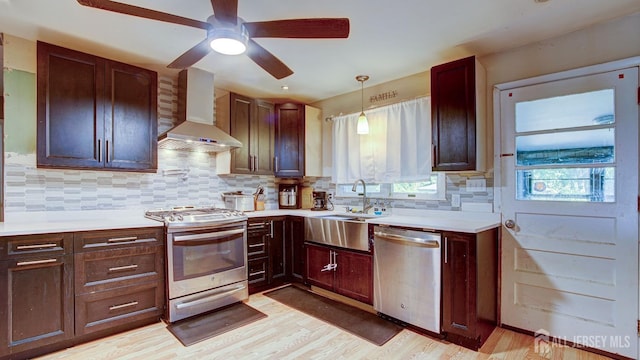 kitchen with decorative backsplash, wall chimney exhaust hood, pendant lighting, and appliances with stainless steel finishes