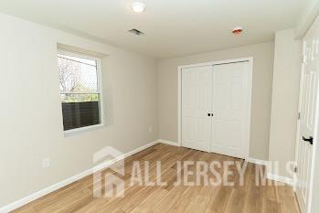 unfurnished bedroom featuring a closet, wood finished floors, and baseboards