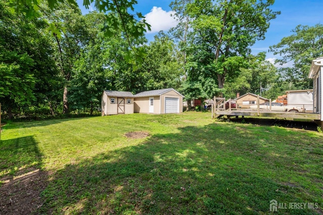 104 Old Matawan Rd, Old Bridge, NJ 08857 - view of green lawn with a storage shed, a deck, view of scattered trees, and a detached garage