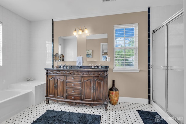 bathroom featuring a bath, a stall shower, double vanity, and baseboards