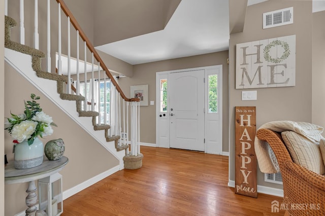 entryway featuring baseboards, wood finished floors, and stairway