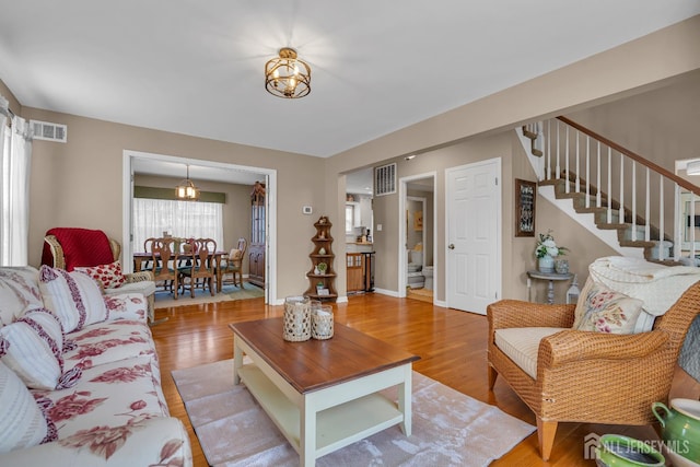 living room with light wood-type flooring and stairway