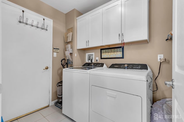 laundry area with cabinet space, washer and clothes dryer, and light tile patterned floors