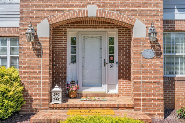doorway to property with brick siding