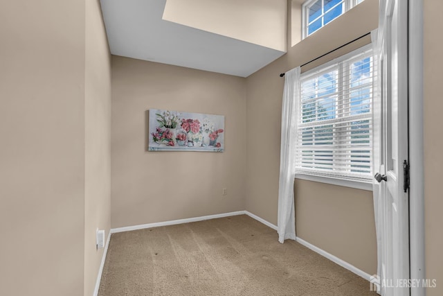 unfurnished room featuring plenty of natural light, carpet flooring, and baseboards