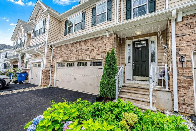 18 Larkspur Ln, Monroe, NJ 08831 - doorway to property with an attached garage, asphalt driveway, and stone siding