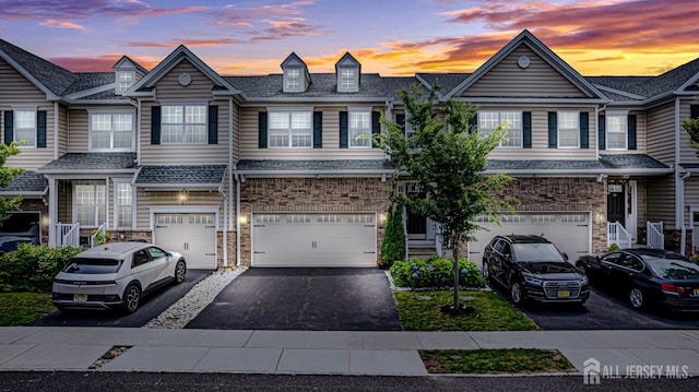 18 Larkspur Ln, Monroe, NJ 08831 - townhome / multi-family property with an attached garage, driveway, stone siding, and a shingled roof