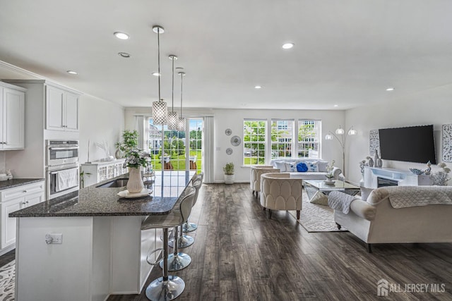 18 Larkspur Ln, Monroe, NJ 08831 - kitchen with stainless steel double oven, open floor plan, dark wood finished floors, white cabinets, and recessed lighting