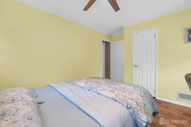 bedroom with dark wood-style flooring, baseboards, ornamental molding, and ceiling fan