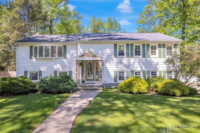 raised ranch featuring a front lawn and a chimney