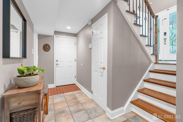 foyer featuring stairs, baseboards, and recessed lighting