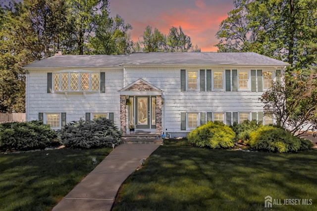 split foyer home featuring a front lawn and a chimney