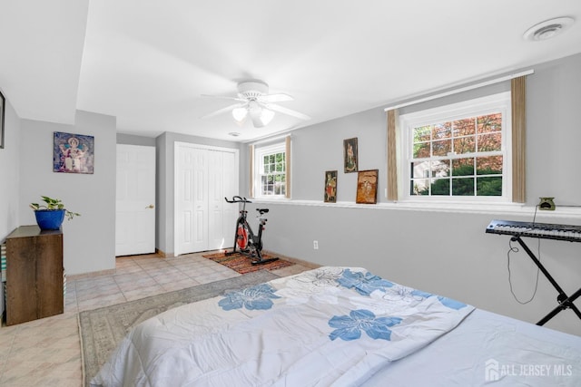 bedroom featuring ceiling fan, a closet, baseboards, and tile patterned flooring