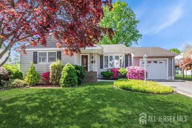 view of front of home with a garage, driveway, and a front lawn