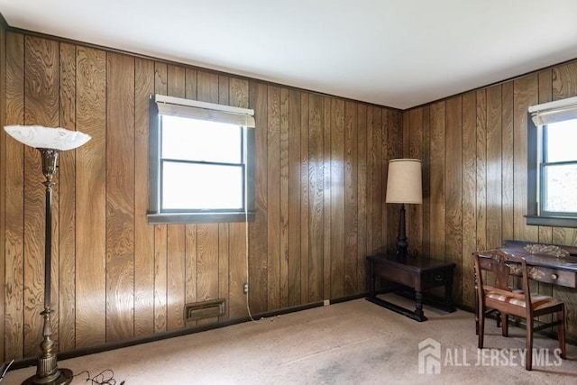 carpeted office space featuring wood walls