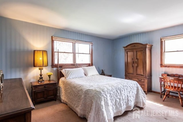 bedroom featuring light colored carpet and baseboards