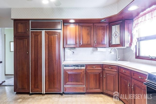kitchen featuring paneled appliances, wallpapered walls, light flooring, a sink, and light countertops
