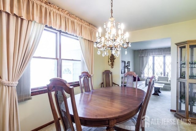 carpeted dining space featuring a chandelier