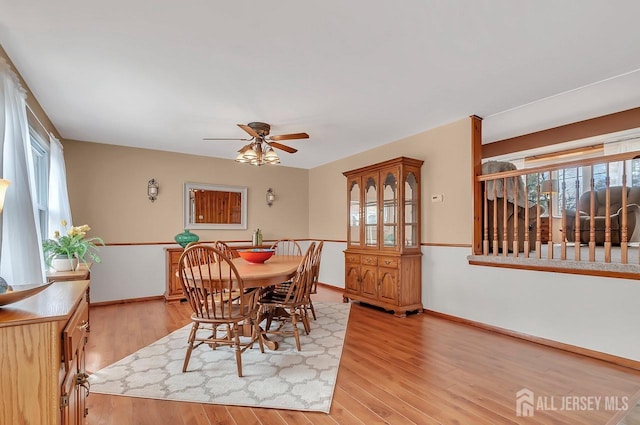 dining area with plenty of natural light, a ceiling fan, light wood-style floors, and baseboards