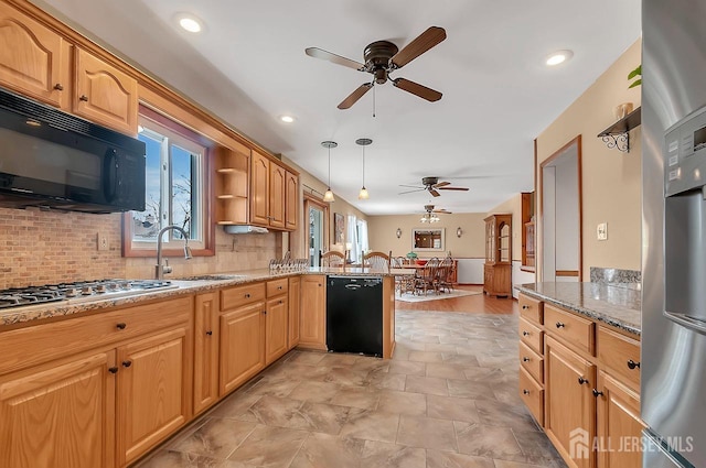 kitchen with black appliances, ceiling fan, a sink, a peninsula, and backsplash