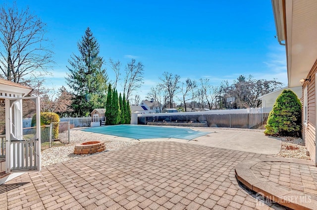 view of swimming pool with an outdoor fire pit, a patio area, and a fenced backyard