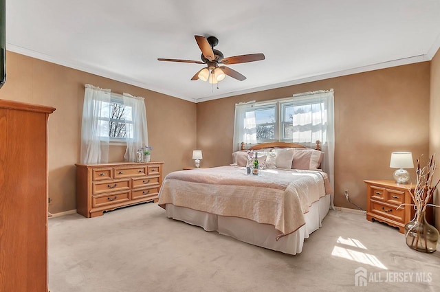 bedroom with multiple windows, light carpet, crown molding, baseboards, and a ceiling fan
