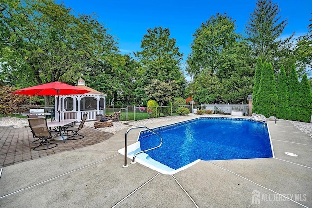 view of swimming pool with a patio area, a gazebo, a fenced backyard, a fire pit, and a grill