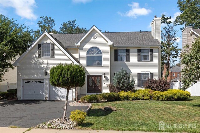 view of front of house featuring a front yard and a garage